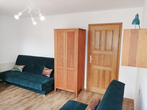 a living room with a blue couch and a wooden door at Willa Tarma in Władysławowo