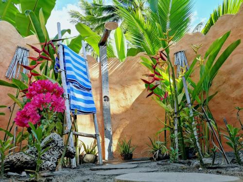 a blue and white chair in a garden with flowers at Coconut Garden Beach Resort in Maumere