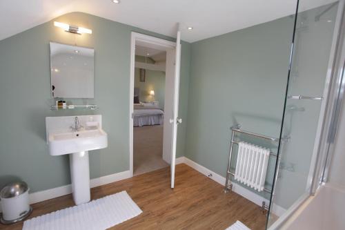 a bathroom with a sink and a glass shower at Thistlebank Townhouse in Whitby