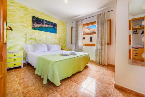 a bedroom with a bed with a green bedspread at Que Bo in Alcudia