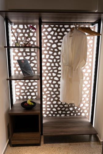 a closet with a white shirt hanging on a rack at Athens Ivy Suites in Athens