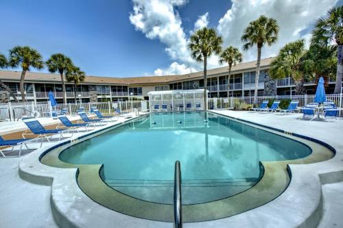 a swimming pool with chairs and a building at Kingston Arms 1st Floor in Sarasota