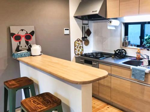 a kitchen with a counter with a cow wearing sunglasses at JR Tokyo family room @Otsuka Bovine 101 in Tokyo