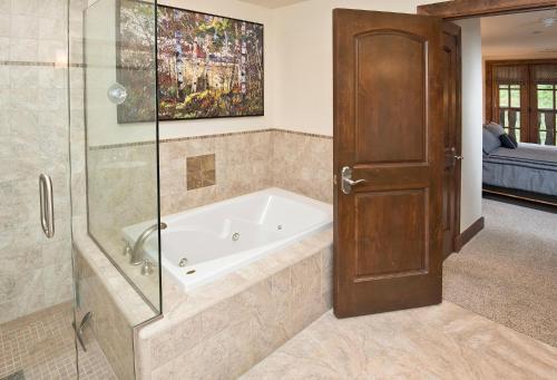 a bath tub in a bathroom with a glass door at Ascent Residence 309 in Avon