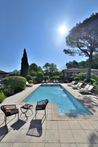 - une piscine avec des chaises et une table à côté dans l'établissement Les Mazets de Marie de Jules, à Eyragues