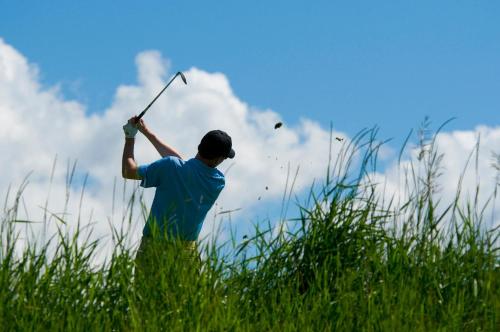 a man swinging a golf club in a field at Ascent Residence 309 in Avon