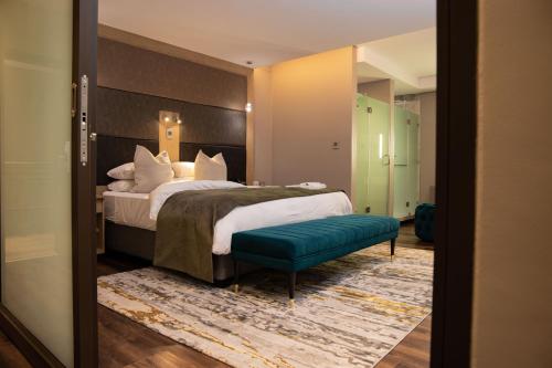 Habitación de hotel con cama y banco verde en Happy Valley Hotel and Casino, en Ezulwini