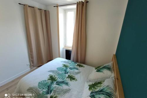 a small bedroom with a bed with a pillow and a window at Appartement zen 1er étage in Cherbourg en Cotentin