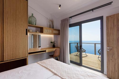 Anemos Luxury Villas في روداكينو: غرفة نوم مع سرير وإطلالة على المحيط
