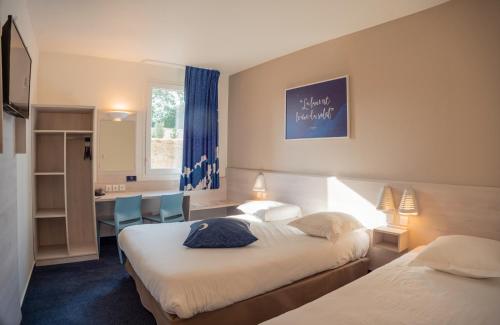 Le Petit-CouronneにあるACE Hôtel Rouen Parc des Expositionsのベッド2台とデスクが備わるホテルルームです。