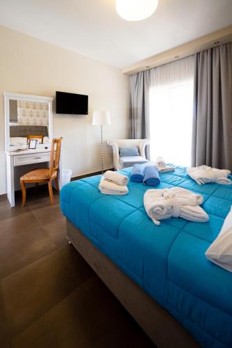 a hotel room with two beds with towels on them at Ornella Beach Resort & Villas in Sivota