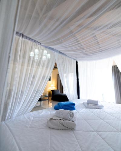 a white bed with white sheets and towels on it at Ornella Beach Resort & Villas in Sivota