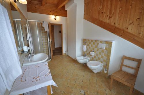 a bathroom with two toilets and a sink and a sink at Ansitz Steiner in Dobbiaco