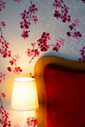 a room with a lamp and a wall with flowers at Ornella Beach Resort & Villas in Sivota