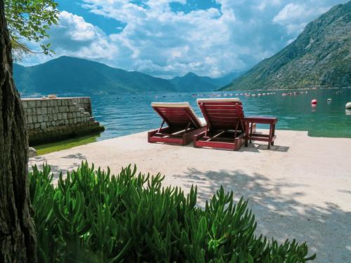 two chairs sitting on the beach near the water at Mareta loft in Kotor