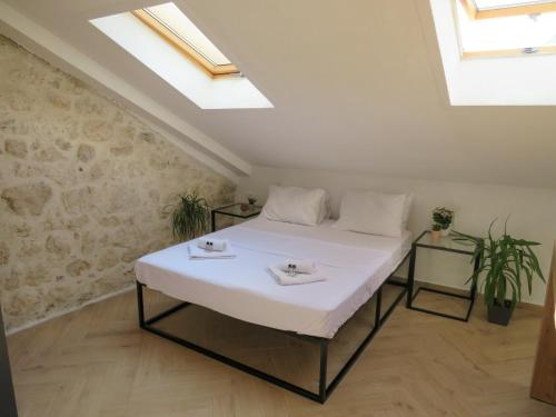 a white bed in a room with skylights at Mareta loft in Kotor