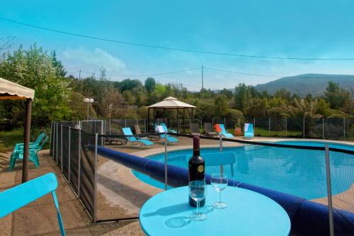 a bottle of wine on a table next to a swimming pool at A Casa Aperta in Favalello