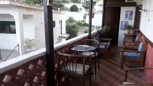 a balcony with tables and chairs on a building at Hotel zakros rooms-restaurant in Zákros