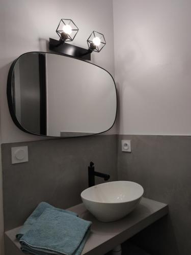 een badkamer met een witte wastafel en een spiegel bij Le Danycan - 18mn à pied gare TGV in Saint-Malo