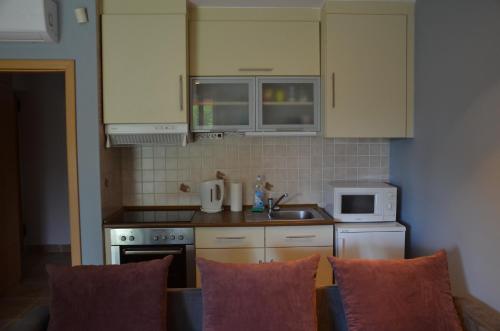 a kitchen with white cabinets and a stove top oven at Vadszilva Apartman in Balatonőszöd