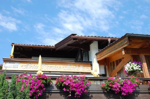 a building with flowers on the front of it at Hotel - Pension - Heidelberg inkl. Chiemgaukarte in Ruhpolding