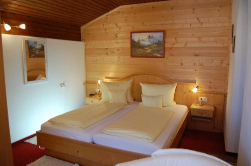 a bedroom with a bed in a wooden room at Hotel - Pension - Heidelberg inkl. Chiemgaukarte in Ruhpolding