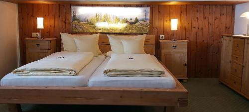 two beds in a room with wood paneling at Hotel - Pension - Heidelberg inkl. Chiemgaukarte in Ruhpolding