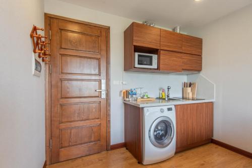 a kitchen with a washing machine and a door at 22Land Moon West Lake in Hanoi