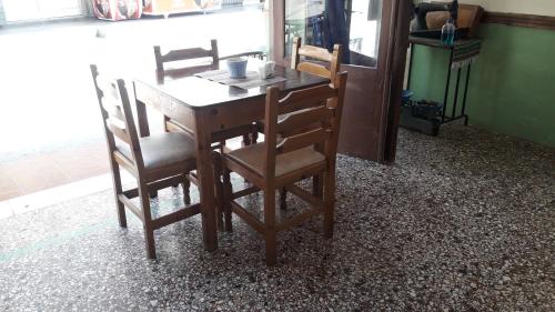 a wooden table and chairs in a room at Hotel zakros rooms-restaurant in Zákros