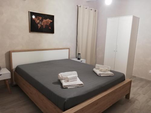 una camera da letto con un letto con due asciugamani sopra di Casa Opuntia Rosolini a Rosolini