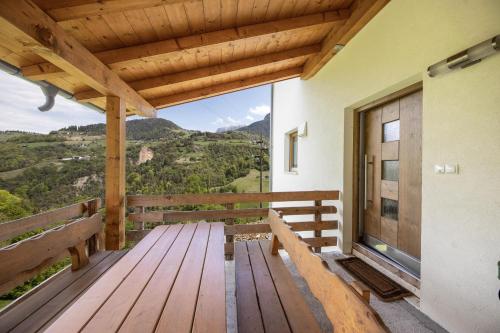 a wooden porch with a bench and a view at Tschafon Oberparnaihof in Collepietra