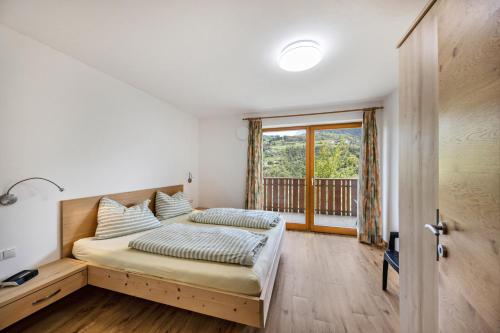een slaapkamer met een bed en een raam bij Tschafon Oberparnaihof in Collepietra