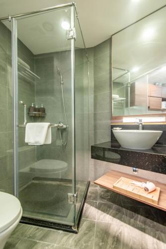 a bathroom with a glass shower and a sink at 22Land Moon West Lake in Hanoi