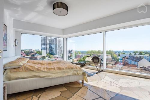 a bedroom with a bed and a large window at Penthouse Frankfurt in Frankfurt