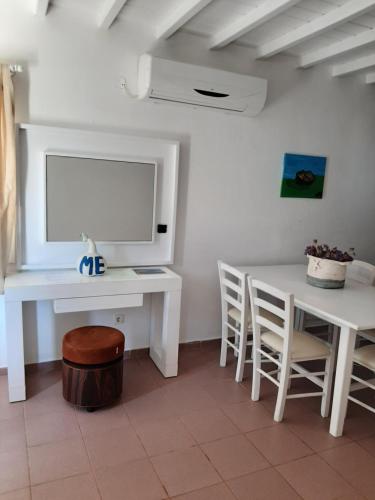 a room with a desk and a table and chairs at Chaniotis Studios in Kalafatis
