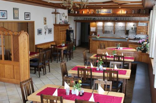 an empty restaurant with wooden tables and chairs at Brauerei und Gasthof Frischeisen in Kelheim