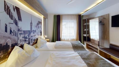 En eller flere senge i et værelse på Hotel Adler