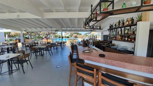 a restaurant with a bar and tables and chairs at Summer Village of Hippokrates - Adults only in Marmari