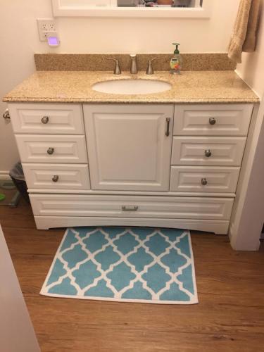 a bathroom vanity with a sink and a blue rug at Alaskan Adventure Awaits! in Eagle River