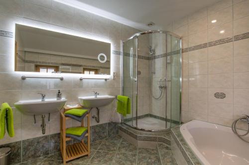 a bathroom with a sink and a shower and a tub at Landhaus Hinteregg Apartment in Schladming