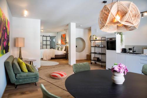 a living room with a dining table and a kitchen at Livingloft Apartments in Bad Saulgau