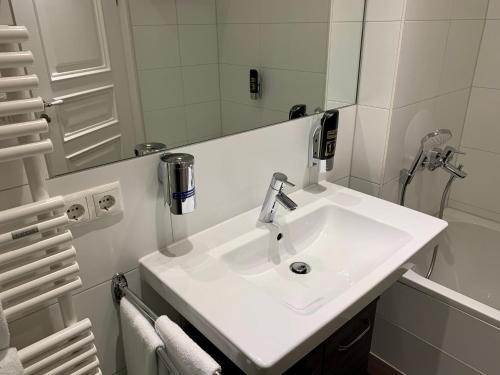 bagno con lavandino bianco e specchio di Familienapartment An der Frauenkirche a Dresda