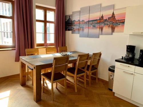 Familienapartment An der Frauenkirche في درسدن: مطبخ وغرفة طعام مع طاولة وكراسي خشبية