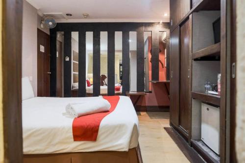 a small bedroom with a bed and a kitchen at RedDoorz near Waterboom Lippo Cikarang in Cikarang