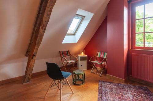 une chambre avec des chaises, une table et une fenêtre dans l'établissement Maison Juvénal des Ursins, à Troyes