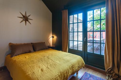 una camera da letto con un letto e una grande finestra di Maison Juvénal des Ursins a Troyes