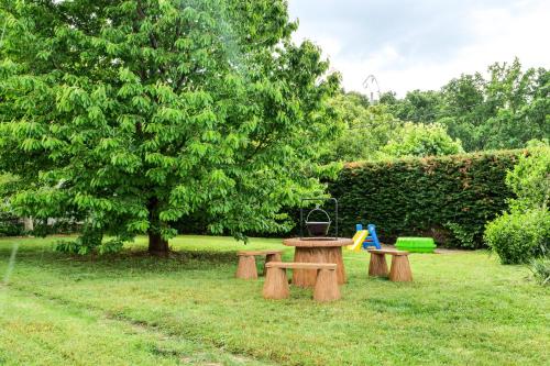 Cseresznyés Apartman في بيريكفوردو: طاولة نزهة ومقعدين في الحديقة