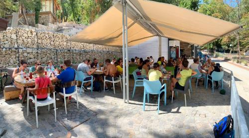 a group of people sitting at tables under a tent at Къщички Синьо лято, Черноморец - Варна - Blue Summer Houses Varna in Varna City