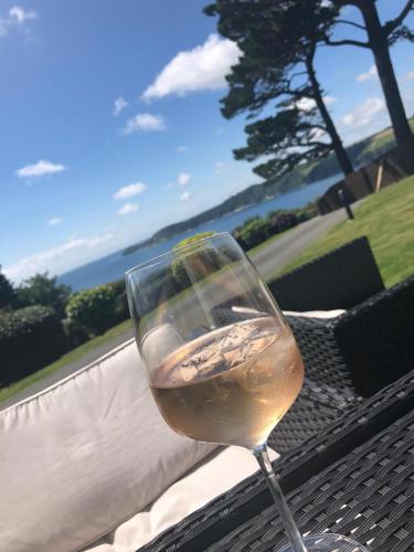 a glass of white wine sitting on a table at Shorthorn Apartment, 53a Sea Road in Carlyon Bay