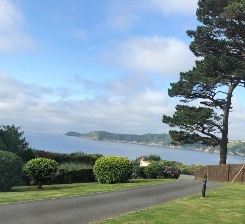 a road leading to a house with a view of a lake at Shorthorn Apartment, 53a Sea Road in Carlyon Bay